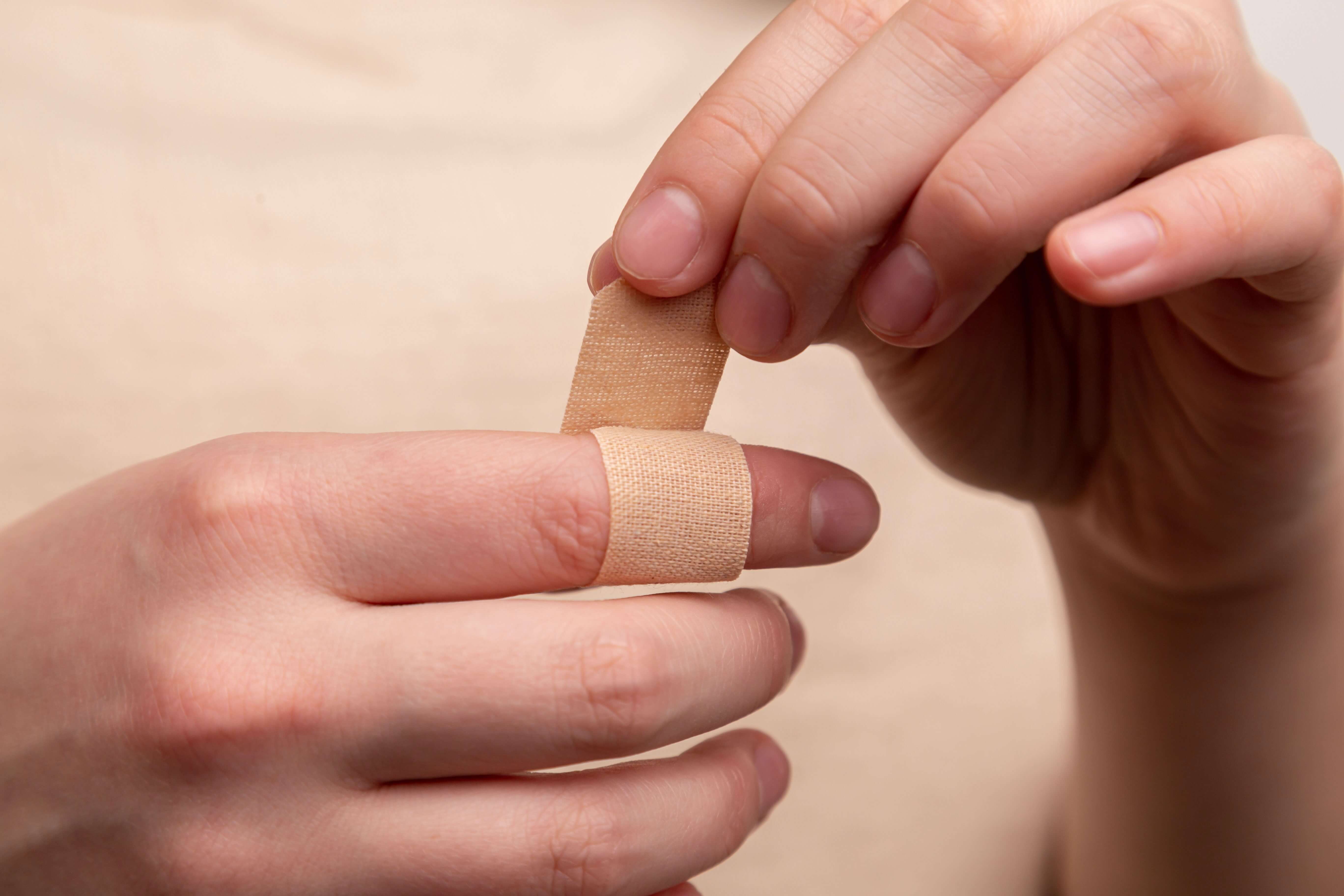 Person putting on band aid on finger