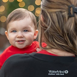 baby smiling with mom showing back of shirt